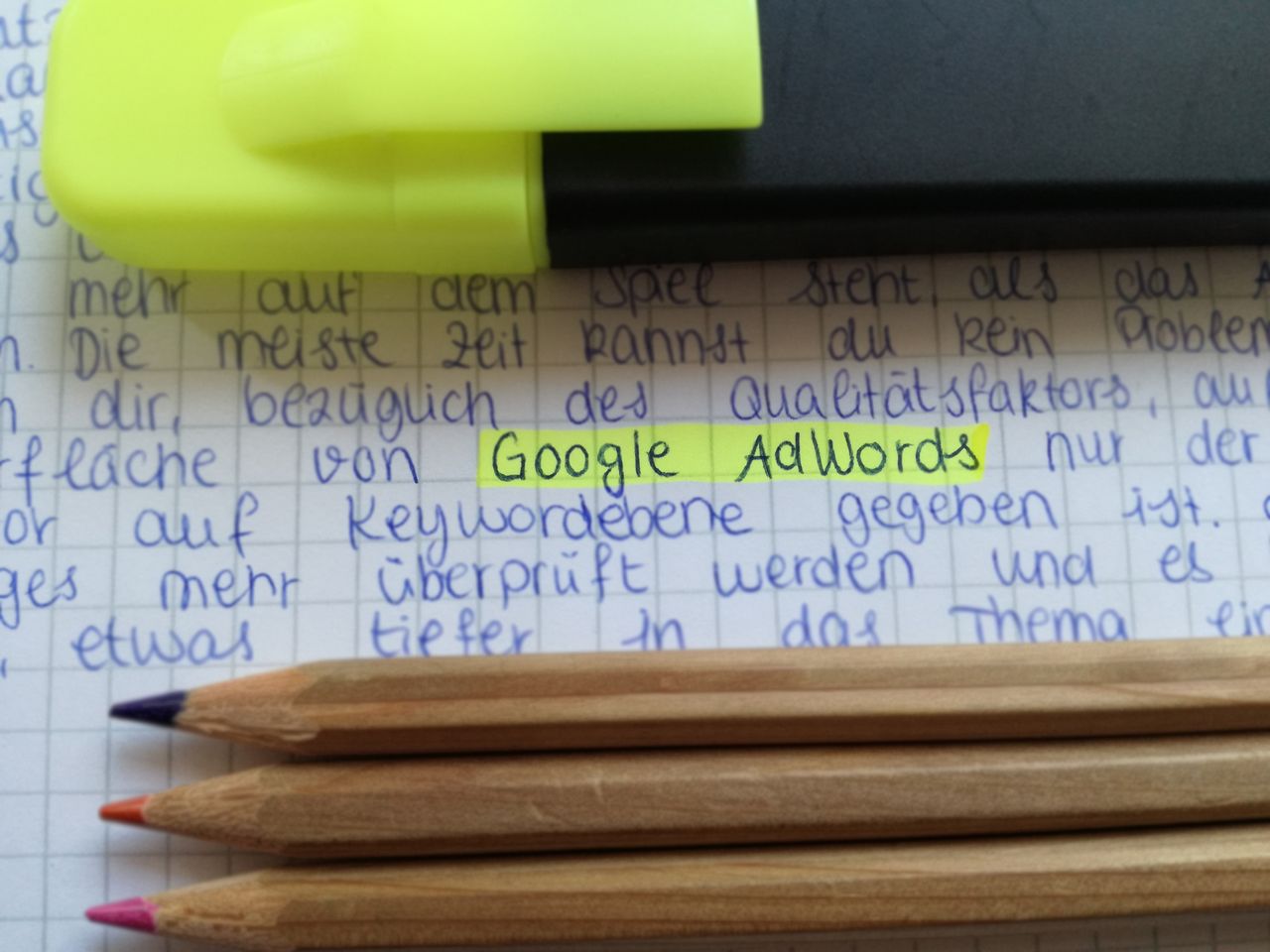 services-03 Close-up of colorful pencils on handwritten notes with Google AdWords highlighted.